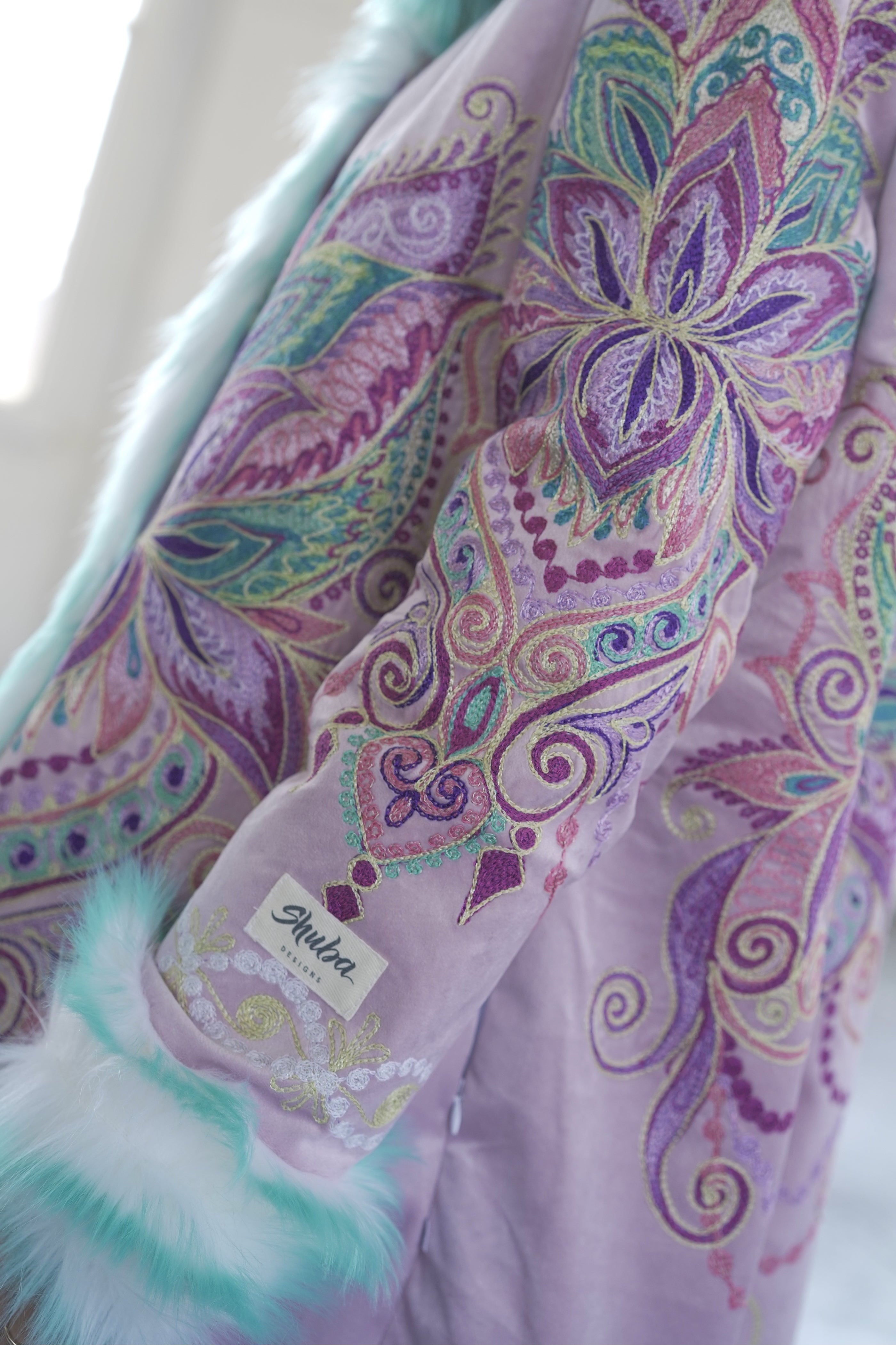 Detailed colorful mandala flower embroidery with mint faux fur trim on Purple Flower coat
