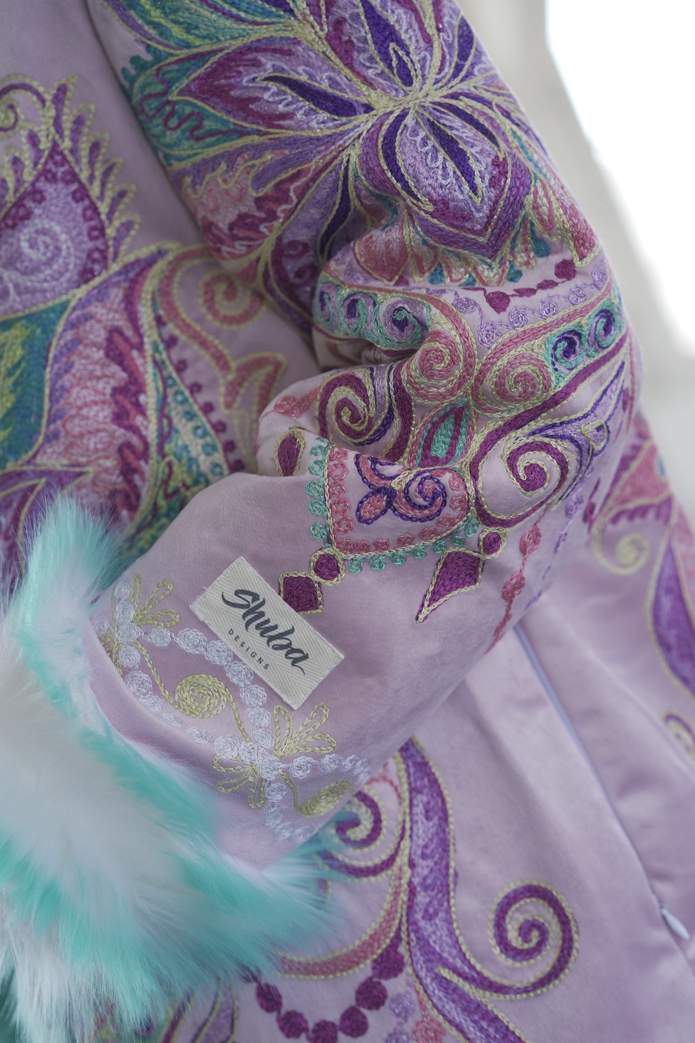 Close-up of colorful Purple Flower mandala embroidery on reversible festival fur coat